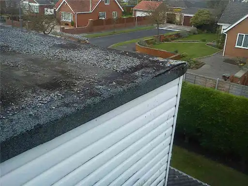 Worn garage felt roof before work