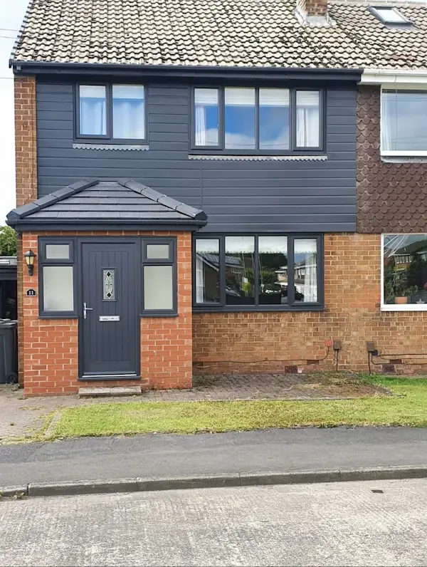 New slate-grey hipped porch roof and anthracite cladding across the front
