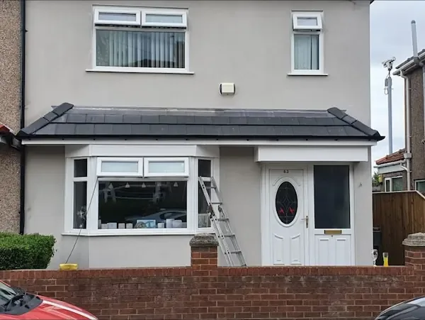 Slate-grey tiled canopy across the front of a rendered house