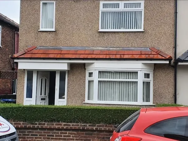 Red tiled canopy over a porch and bay window