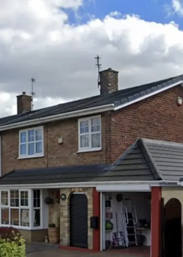 Long tiled pitched roof over a garage, porch and bay window